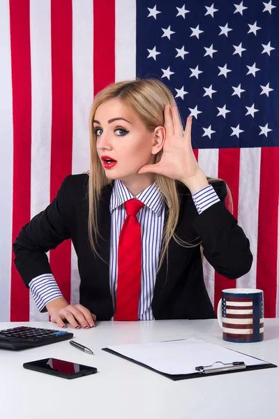 Business, future technology and office concept - Surprise shocked business woman holding hand near ear with fun face on american flag background