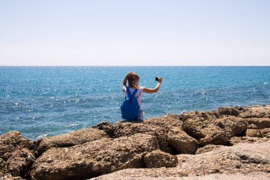 Güzel genç kadın selfie otoportre plaja smartphone ile yapıyor