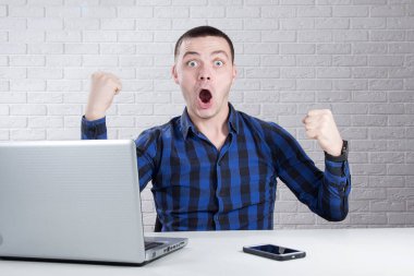 Beyaz arka plan üzerinde yumruklarını mutlu delikanlı kaldırdı 