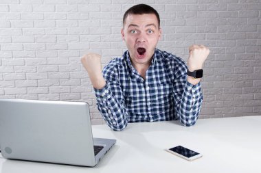 Beyaz arka plan üzerinde yumruklarını mutlu delikanlı kaldırdı 