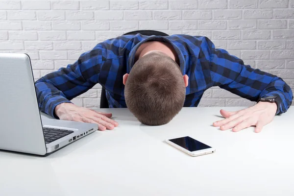 Young businessman lying face down on the desk.