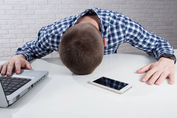 Young businessman lying face down on the desk.