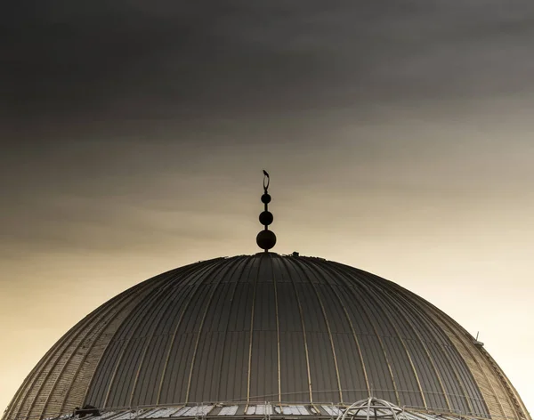 The construction of a concrete dome requires a formwork which itself could have some aesthetic value. The sunset has created a chromatic appearance of the metal-wooden formwork which is visited by a bird.