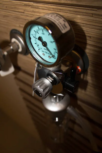 Selective focus on the pressure gauge of an oxygen support system mounted on the wall of a luxury hospital room.