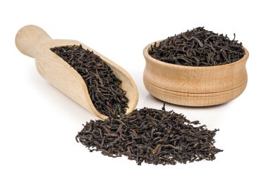 Beyaz arka plan üzerinde izole bir ahşap kürek ile siyah gevşek çay