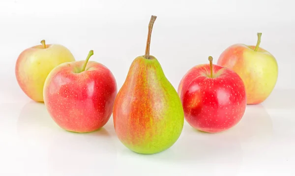 one pear and four apples on a white background