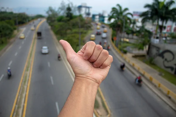 a white hand waving on the road