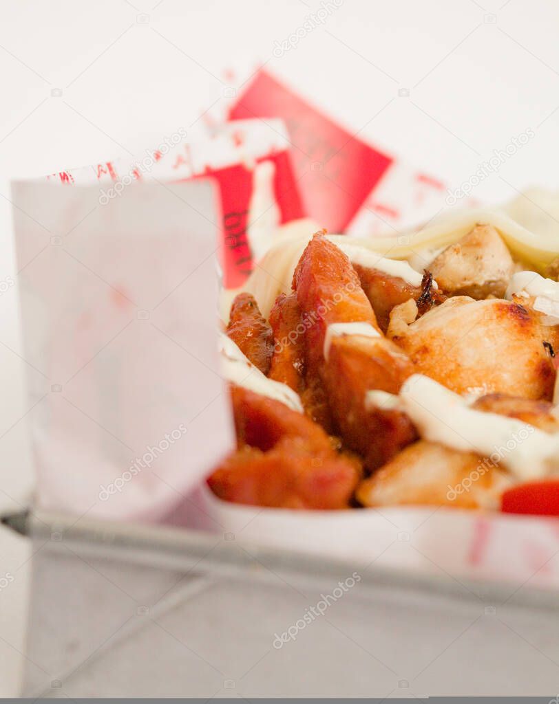 crispy chicken covered with sauces on white background