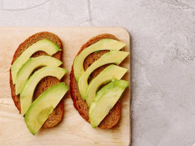 Avokado kara günü sandviçle. Çavdar ekmek taze doğranmış avokado ile yapılan