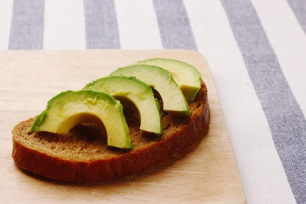 Sandwich con avocado su pane di segale scuro fatto con avocado fresco a fette — Foto Stock