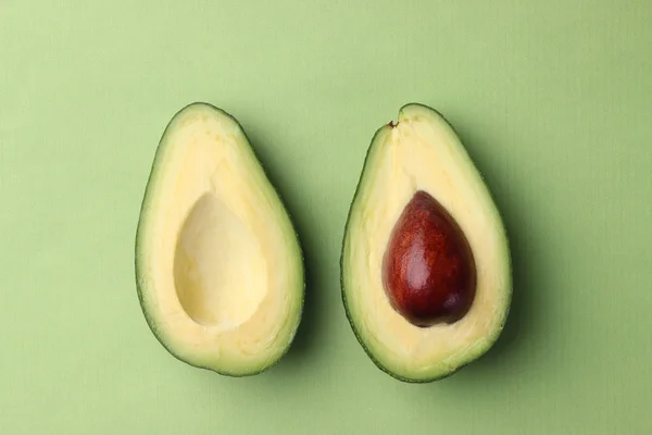 Sliced avocado on green background top view two half with seed — Stock Photo, Image