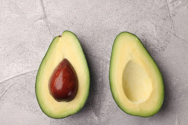 Avokado iki yarısı çimento üzerinde arka plan Üstten Görünüm