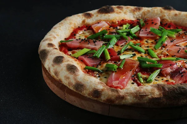 seafood pizza with fresh tuna on dark background