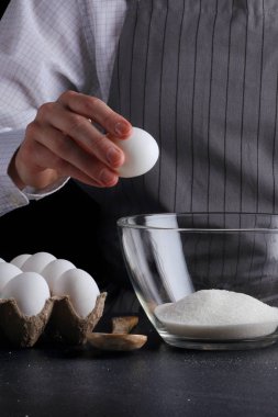 hamur için yumurta kırar. tarifi pasta ya da kek kavramı koyu arka plan üzerinde yapma
