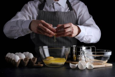 hamur için yumurta kırar. tarifi pasta ya da kek kavramı koyu arka plan üzerinde yapma