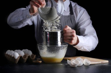 Koyu arkaplanda un eleme. Turta ya da pasta yapma konsepti