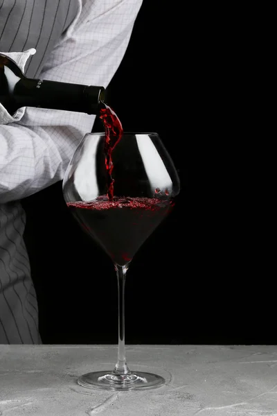 Rotwein im Glas. Barkeeper auf Kellner-Konzept auf schwarzem Hintergrund — Stockfoto