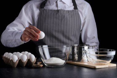 Şef pasta yapıyor. Turta yapmak. Koyu arkaplanda tarif kavramı