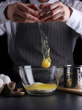 hamur için yumurta kırar. tarifi pasta ya da kek kavramı koyu arka plan üzerinde yapma