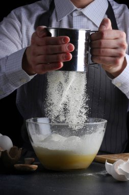 Şef pasta yapıyor. Turta yapmak. Koyu arkaplanda tarif kavramı