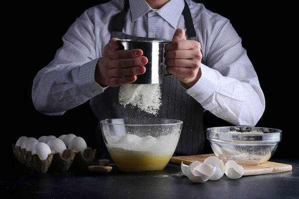 sifting flour in bowl. man cooking dessert concept