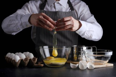 hamur için yumurta kırar. tarifi pasta ya da kek kavramı koyu arka plan üzerinde yapma