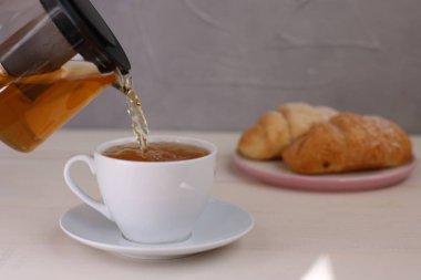 çay hafif arka plan üzerinde fincan dökme. çaydanlık ve kahvaltı konsepti