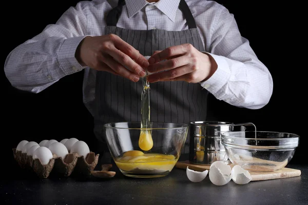 hamur için yumurta kırar. tarifi pasta ya da kek kavramı koyu arka plan üzerinde yapma