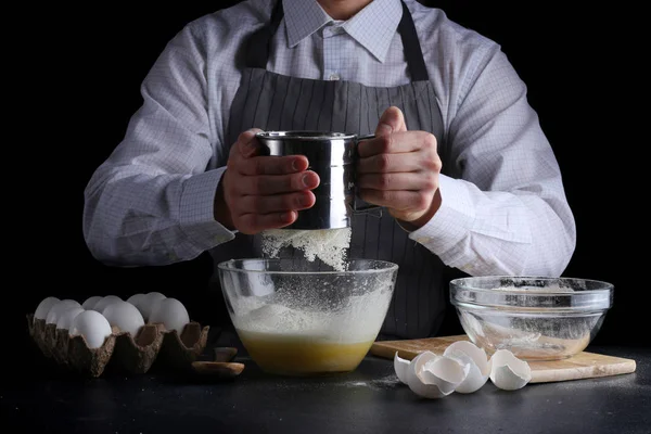 sifting flour in bowl. man cooking dessert concept