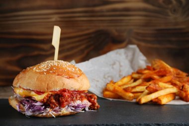 rustik arka planda peynir ve sebze ve patates kızartması ile burger