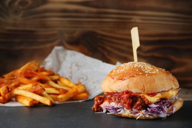 rustik arka planda peynir ve sebze ve patates kızartması ile burger