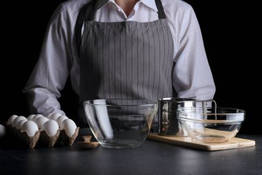 Şef pasta yapıyor. Turta yapmak. Koyu arkaplanda tarif kavramı