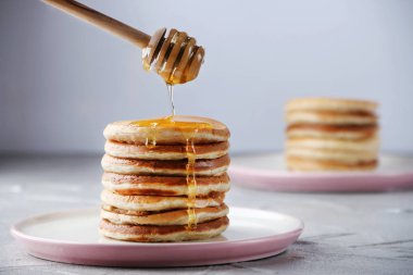 Bal dökme ile pancake yığını. ışık arka planda dekorasyon kavramı