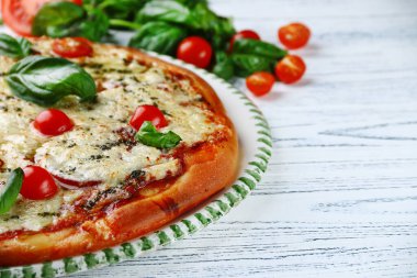 Domatesli İtalyan turtası, peynirli fesleğen ve hafif ahşap kaplama. İtalyan margherita pizzası, domates peyniri ve fesleğen yaprağı.