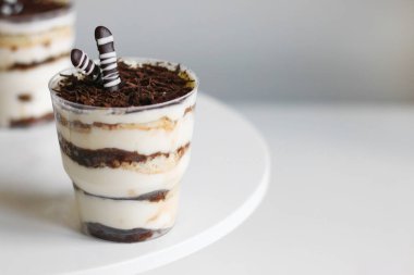 Cam ve hafif arka planda klasik tiramisu. Işık arkaplanındaki bölümlendirilmiş tiramisu