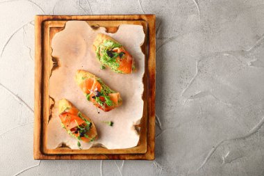 Ahşap manzaralı somonlu bruschetta. Füme somon tostu, guacamole ve mikroyeşil..