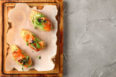 Ahşap manzaralı somonlu bruschetta. Füme somon tostu, guacamole ve mikroyeşil..