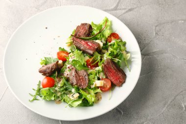 Salata yapraklı biftek salatası taze vişneli domates parmesan peyniri ve yaz sosu yakın plan..