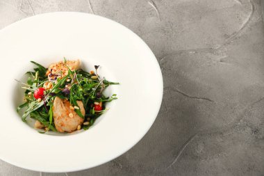 Tavuk roka ve çam fıstıklı salata. Beyaz tabakta yakın plan.