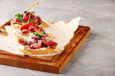 Ahşap güvertede sığır eti ve siyah arka planda geleneksel İspanyol tapas seti. topas veya bruschetta sığır eti ve mikroyeşil.
