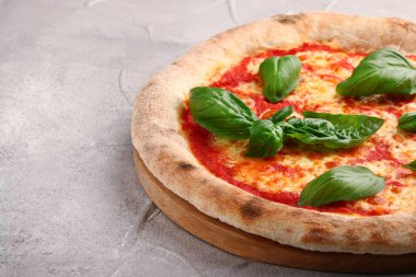 Domatesli pizza, fesleğen ve Mozzarella peyniri açık beton masaya yakın çekim.