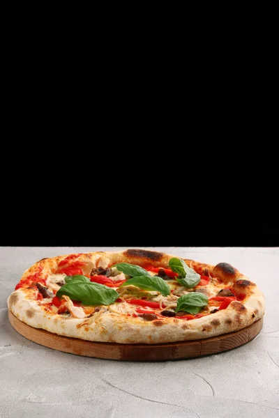 pizza with mushrooms, tomato and chicken close up pizza with mushrooms and chicken on light concrete or stone table