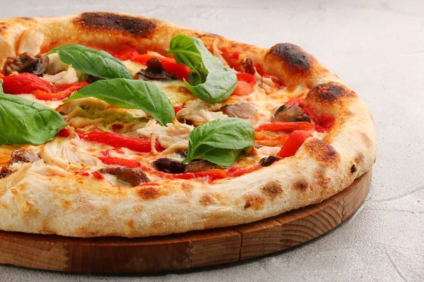 pizza with mushrooms, tomato and chicken close up pizza with mushrooms and chicken on light concrete or stone table