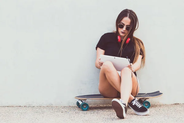 Ung Kvinna Sitter Skateboard Och Hålla Tablett — Stockfoto