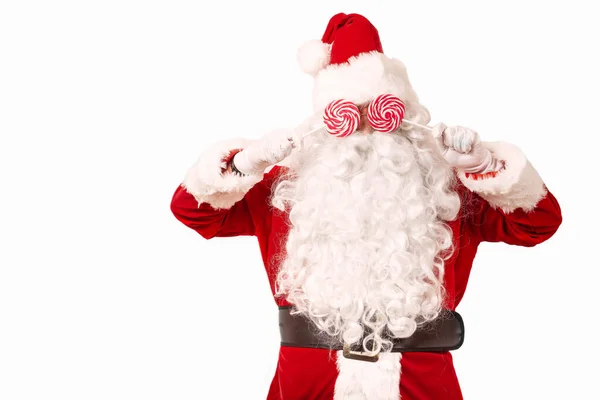 Santa Claus cubierto la cara sosteniendo piruletas en las manos — Foto de Stock