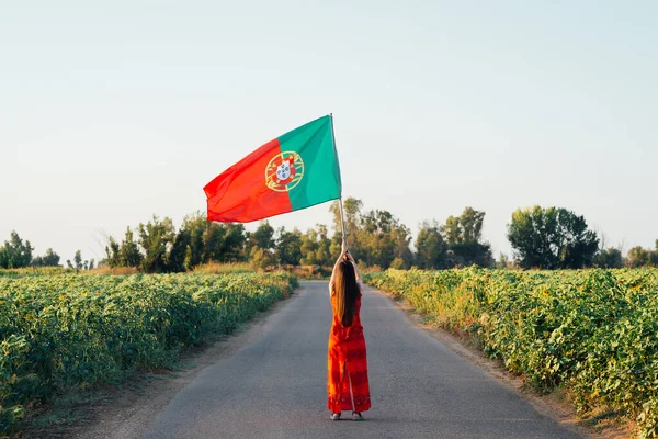 道路にポルトガル国旗を掲げた女性は ストック写真