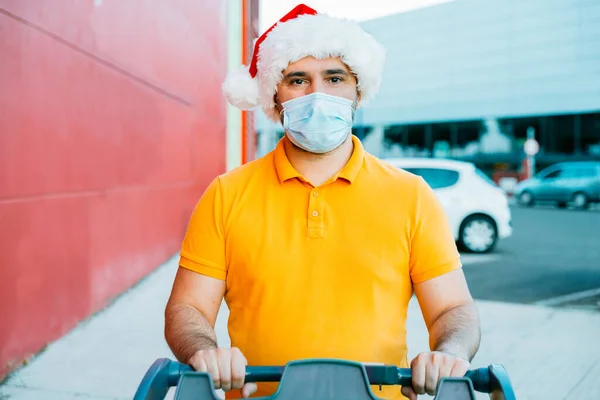 Hombre maduro con máscara médica y compras sombrero de Navidad — Foto de Stock