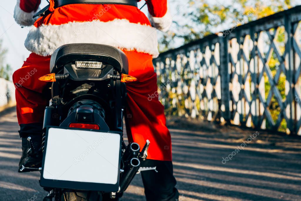 Santa Claus riding a motorcycle on his back wit copy space for text