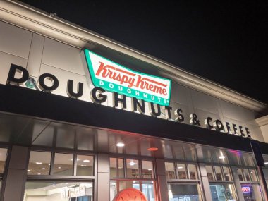 Portland, Ore - March 24 2019: Krispy Kreme Doughnuts storefront at night. clipart