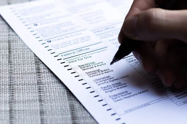 手里拿着笔的人在想在2020年美国总统选举中该投谁的票 美国俄勒冈州波特兰 2020年10月 免版税图库照片